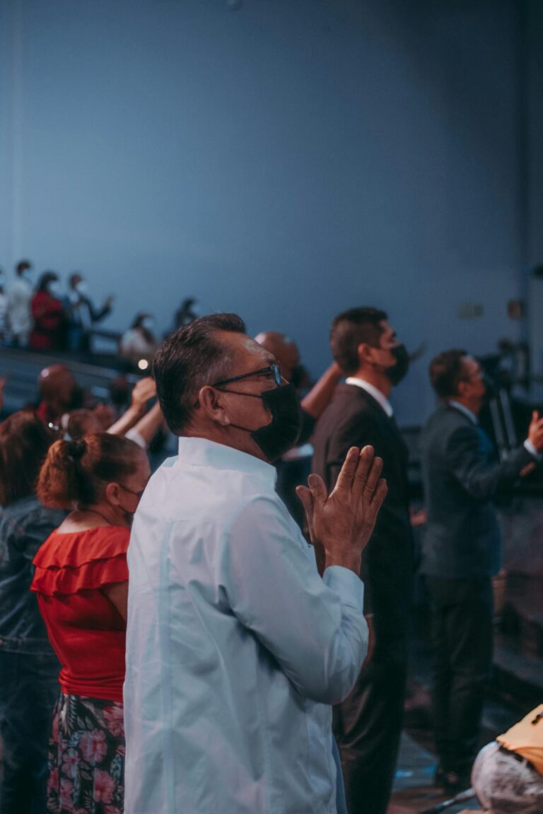 A group of masked individuals participating in a religious service indoors.