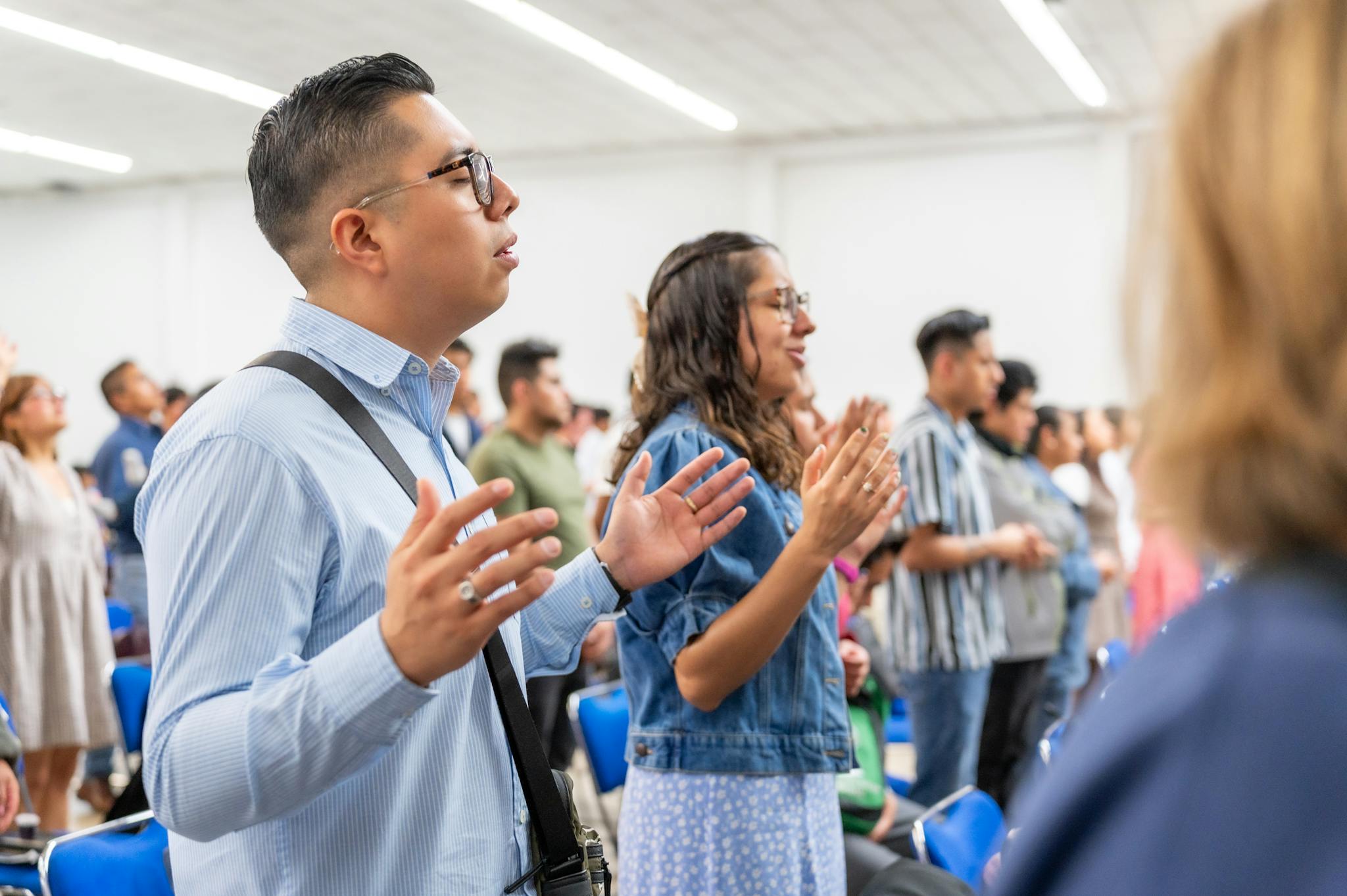 Group of people raising hands in worship during a religious gathering in Ciudad de México.